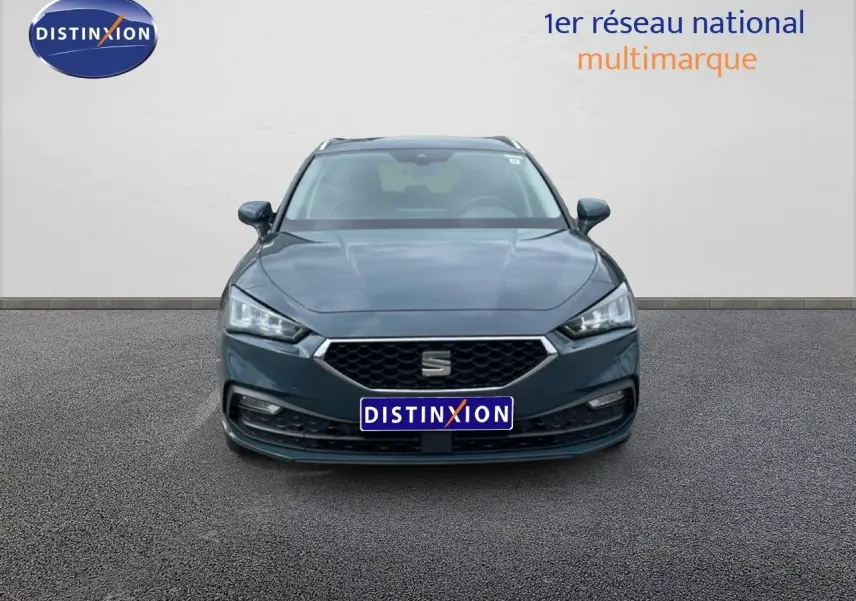 Vue de face d'une SEAT LEON ST 2.0 TDI bleu Fjord avec calandre hexagonale et phares LED allumés.