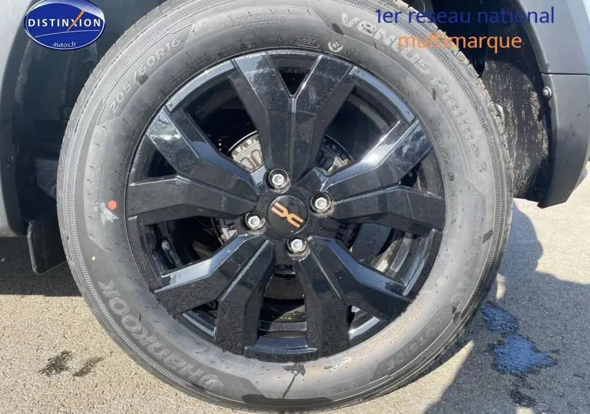 Gros plan sur la jante alu noire du côté avant droit d'une Dacia Sandero gris schiste 2025.