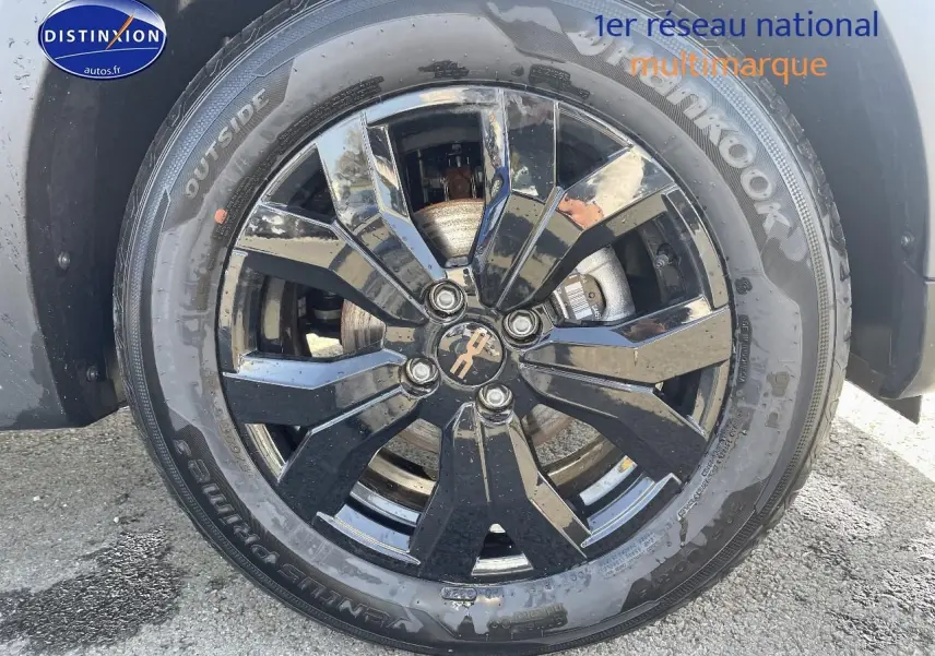 Gros plan sur la jante noire brillante et le pneu Hankook d'une Dacia Sandero Stepway gris schiste.