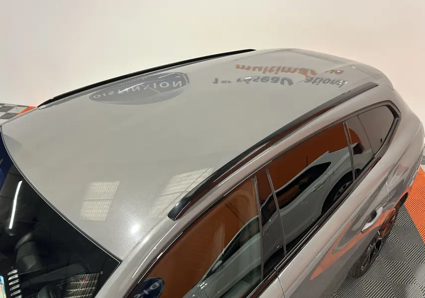 Vue plongeante sur le toit gris Selenium et la partie droite d'un Peugeot 508 SW 2024 avec barres de toit noires.