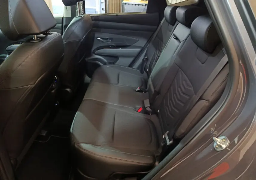 Vue intérieure côté droit des sièges arrière en tissu noir du Hyundai Tucson 1.6 Hybrid 2025 gris clair.