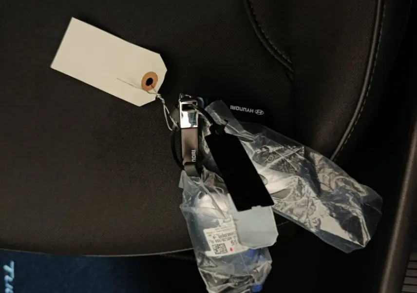 Clé de voiture Hyundai Tucson posée sur un siège tissu noir à l'intérieur du véhicule.