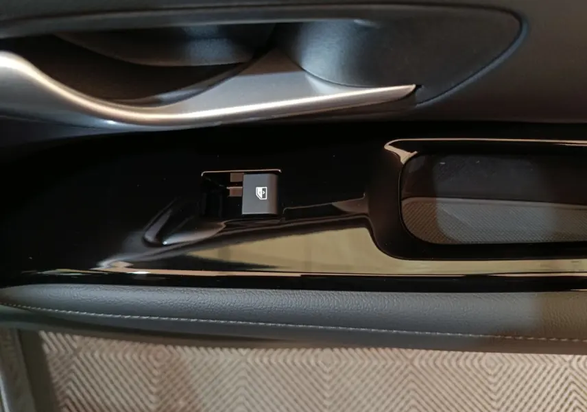 Gros plan sur la commande de lève-vitre côté conducteur du Hyundai Tucson gris clair 2025, finition Creative.