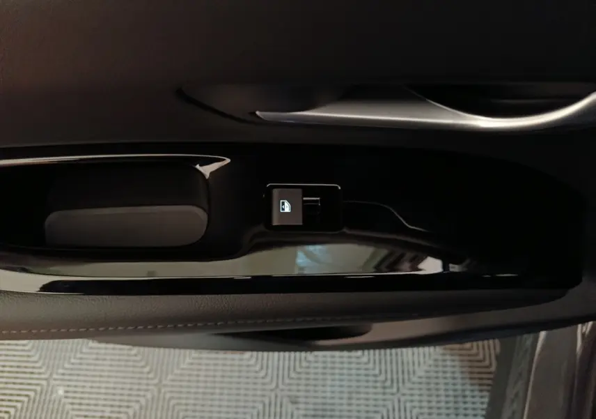 Gros plan sur la commande de verrouillage centralisée noire sur la portière intérieure côté conducteur du Hyundai Tucson gris clair 2025.