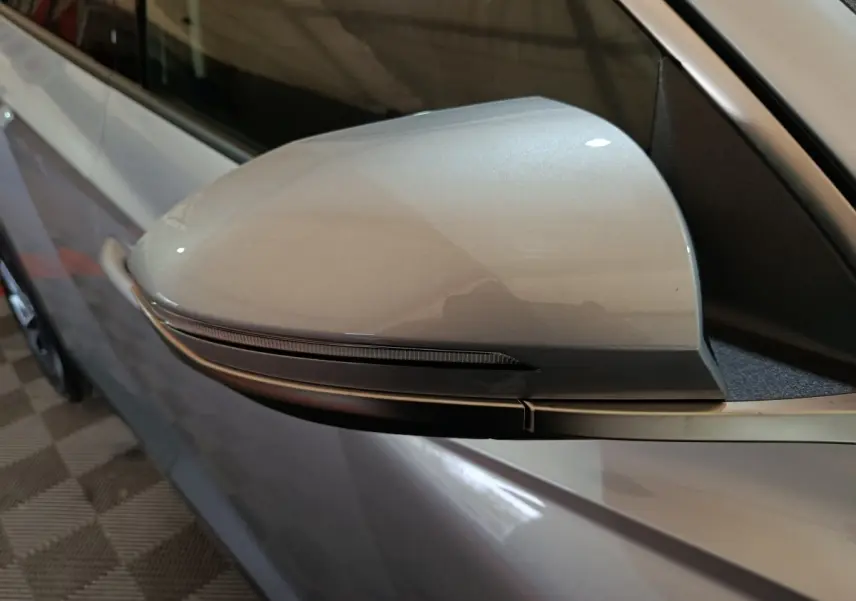 Rétroviseur côté conducteur gris clair du Hyundai Tucson 1.6 Hybrid 239 Creative Auto, avec clignotant intégré.