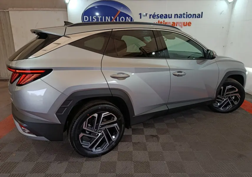 Vue latérale droite d'un Hyundai Tucson 1.6 Hybrid gris clair avec feux arrière LED et jantes alliage distinctives.