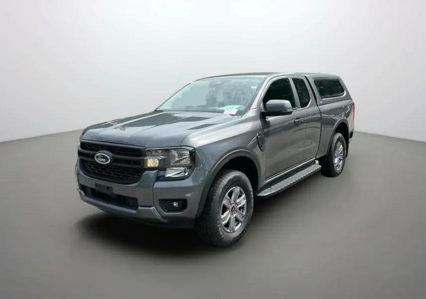 Ford Ranger gris carbone en 3/4 avant droit avec hard-top et marchepieds latéraux visibles.