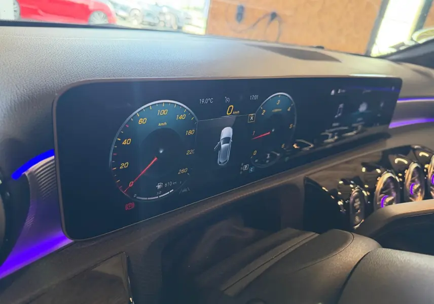 Tableau de bord numérique de Mercedes Classe A 220D AMG Line 2019, affichage clair avec éclairage d’ambiance violet.