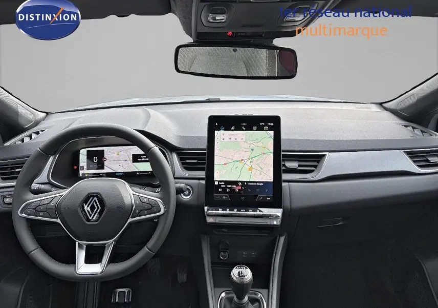 Vue intérieure frontale du tableau de bord du Renault Captur II 1.6 E-TECH hybride avec écran tactile vertical et volant multifonction.