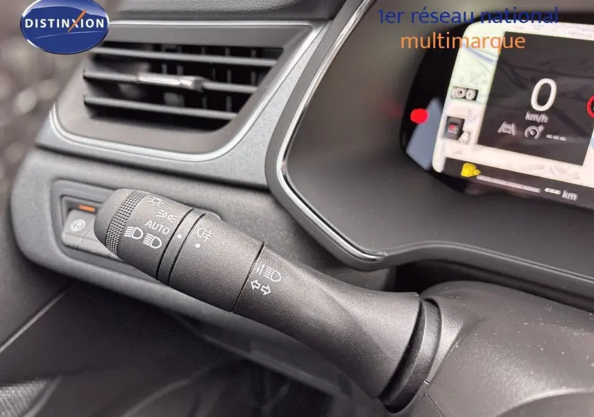 Gros plan sur la commande des feux et clignotants du tableau de bord gris noir du Renault Captur hybride 2025.