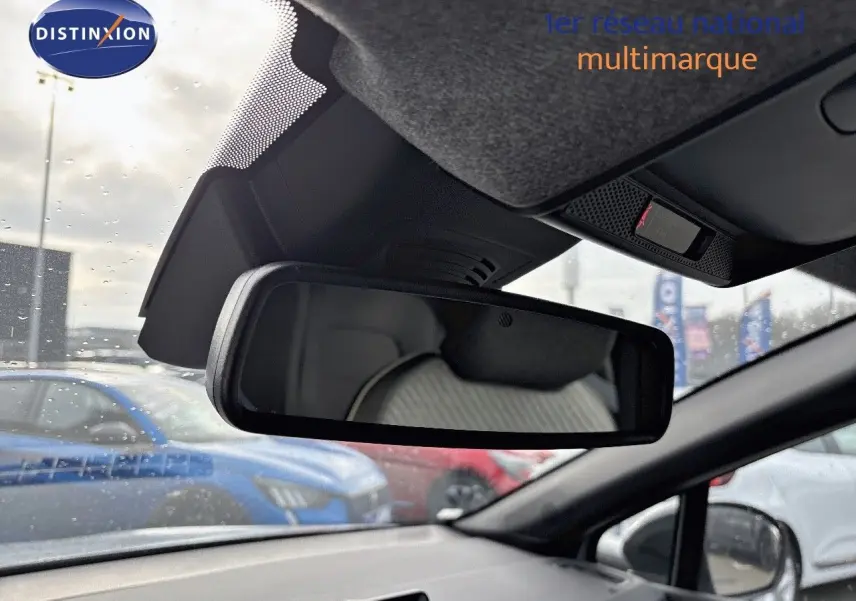 Vue intérieure du rétroviseur central d’un Renault Captur gris Rafale métal avec toit noir, montrant l’arrière du siège conducteur.