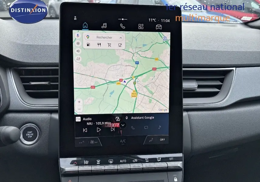 Vue intérieure centrée sur l’écran tactile vertical du tableau de bord du Renault Captur gris Rafale 2025 avec toit noir.