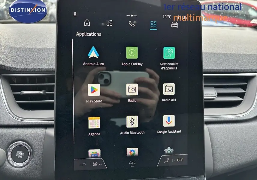 Vue intérieure centrée sur l'écran tactile multimédia du Renault Captur II gris Rafale métal avec toit noir.