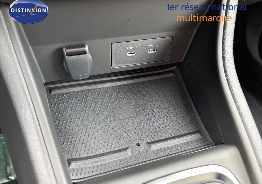 Gros plan sur la console centrale du Renault Captur II hybride, montrant les ports USB-C et un espace de rangement noir texturé.