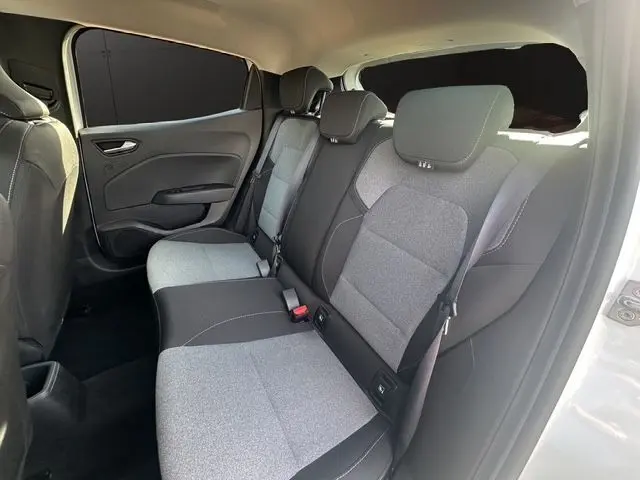 Vue intérieure arrière droite de la Renault Clio V blanche, banquette 3 places avec sellerie textile gris à motif 3D.