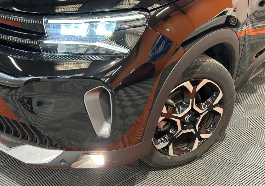 Gros plan sur l'avant droit noir Perla Nera du Citroën C5 Aircross Ph.2 MAX Hybride avec feux LED et jante alliage distinctive.
