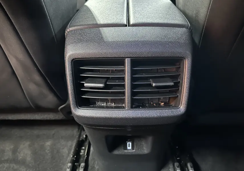 Grille d'aération arrière noire avec prise USB, vue rapprochée de l'intérieur du Citroën C5 Aircross Ph.2 Max Hybride.