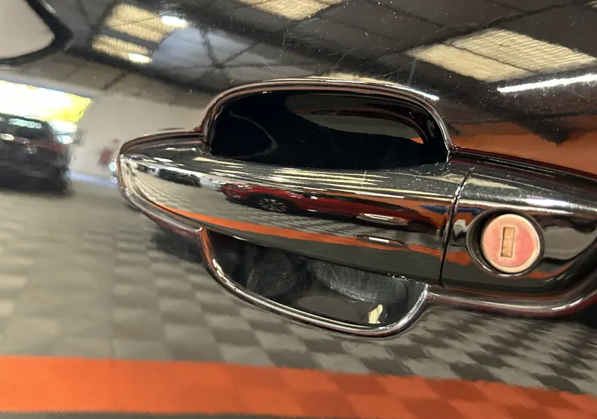 Poignée de porte noire brillante du Citroën C5 Aircross Ph.2 MAX Hybride 2024 avec serrure intégrée, vue rapprochée côté gauche.