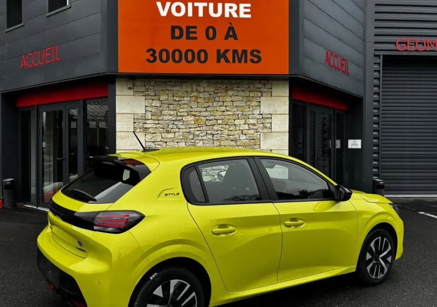 Vue 3/4 arrière droite d'une Peugeot 208 Hybrid jaune vif, finition Style, stationnée devant un bâtiment avec panneau orange.