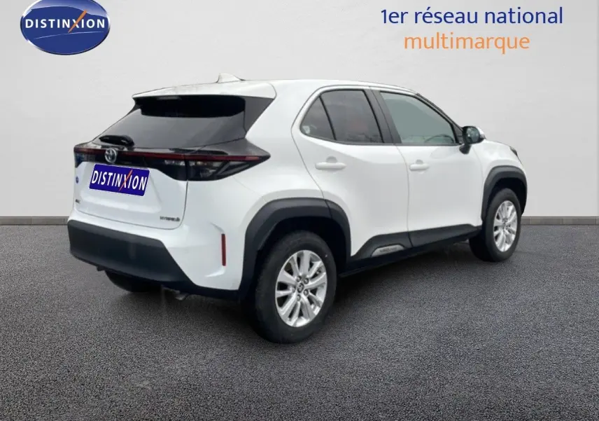 Toyota Yaris Cross Hybrid blanc vue 3/4 arrière droit, avec protections noires et jantes alliage argentées.