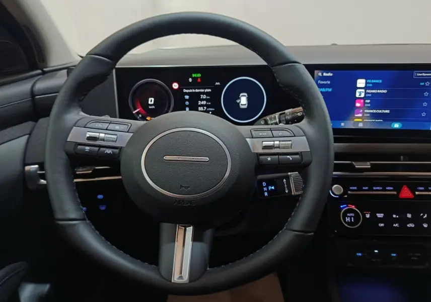 Vue intérieure centrée sur le volant cuir noir et l'écran tactile large du tableau de bord du Hyundai Tucson 2025.