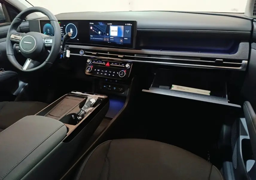Vue intérieure du tableau de bord et console centrale du Hyundai Tucson 1.6 Hybrid 239 Creative, finition noire avec écran tactile large.