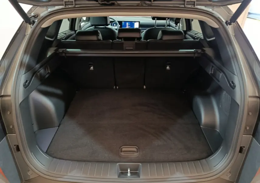 Coffre ouvert d’un Hyundai Tucson gris foncé, vue arrière montrant l’espace de chargement et l’intérieur noir.