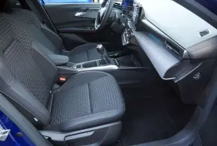 Vue intérieure côté conducteur de la Renault Clio VI 6 TCE 115 Techno Plus bleu iron, avec sièges tissu noir et console centrale moderne.