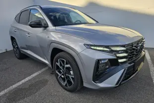 Hyundai Tucson 2025 gris argenté en vue 3/4 avant droit avec calandre N Line et jantes alliage noires.