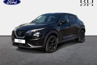 Nissan Juke noir métallisé vu en 3/4 avant droit, avec jantes noires et signature lumineuse distinctive.