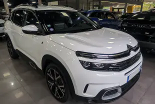 Citroën C5 Aircross hybride rechargeable blanc glacier vue 3/4 avant en intérieur avec jantes noires bicolores.