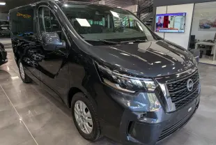 Vue 3/4 avant droit du Nissan Primastar Combi gris comète, mettant en valeur sa calandre chromée et ses phares modernes.