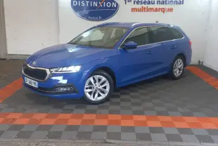 Vue 3/4 avant droite d'une Skoda Octavia break bleu 2022, avec jantes alliage et phares LED allumés.