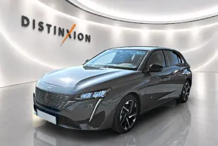 Peugeot 308 gris selenium vue 3/4 avant droit en intérieur avec éclairage moderne et jantes alu distinctives.