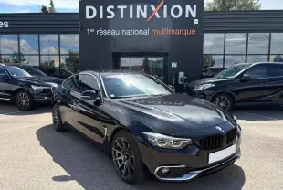 BMW Série 4 Gran Coupé noir saphir vue 3/4 avant droit avec jantes alliage et calandre chromée devant concessionnaire Distinxion