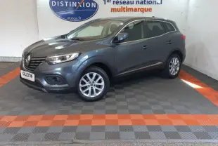 Renault Kadjar Business gris foncé en 3/4 avant droit, avec jantes alliage et phares LED visibles en intérieur showroom.