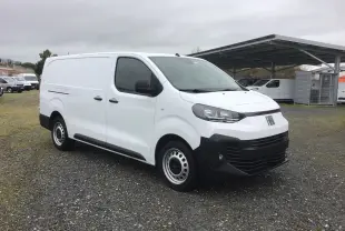 Fiat Scudo Fourgon blanc vu en 3/4 avant droit, avec pare-chocs noirs et jantes acier, sur parking extérieur.