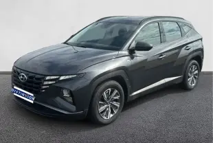 Hyundai Tucson gris 2023 en 3/4 avant droit, avec calandre distinctive et jantes alliage modernes.