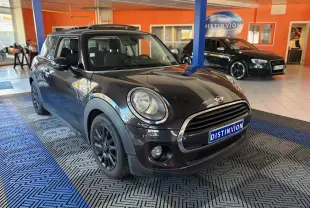 Vue 3/4 avant gauche d'une MINI Cooper D 2015 noire avec jantes foncées, exposée en showroom intérieur.
