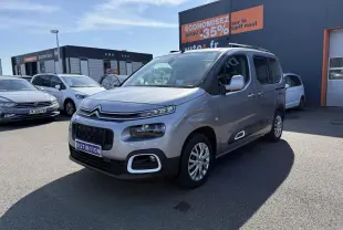 Citroën Berlingo gris foncé vu en 3/4 avant droit, avec ses phares distinctifs et coques de rétroviseurs ton caisse.
