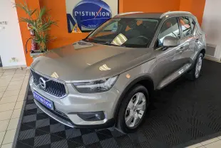 Vue 3/4 avant droite d'un Volvo XC40 marron clair en showroom avec jantes alliage et toit panoramique.