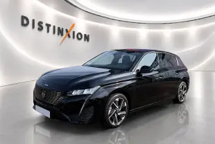 Peugeot 308 noire vue en 3/4 avant droit, avec jantes alliage et phares LED distinctifs dans un showroom lumineux.