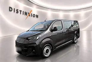Vue 3/4 avant droite du FIAT Scudo Combi gris titane avec porte latérale coulissante dans un showroom lumineux.