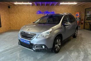 Peugeot 2008 gris vue 3/4 avant droit dans un garage, avec toit ouvrant et jantes alliage visibles.