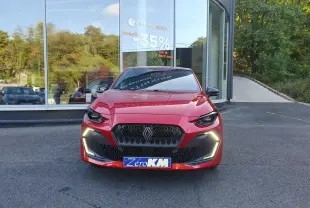 Renault Clio VI rouge absolu vue de face, avec signature lumineuse LED en forme de C et calandre noire hexagonale.