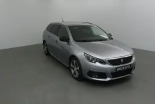 Peugeot 308 SW gris Artense vue 3/4 avant droit, avec jantes alliage et calandre noire distinctive.
