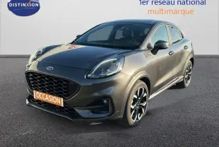Vue 3/4 avant d'une Ford Puma gris foncé avec jantes alliage noires et vitres surteintées sur fond neutre.