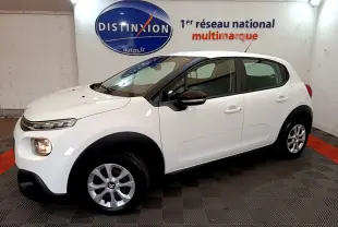 Citroën C3 blanche vue de profil côté gauche, avec feux avant allumés dans un showroom.