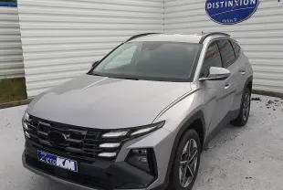 Vue 3/4 avant droite d'un Hyundai Tucson 2025 gris Shimmering Silver avec calandre noire et jantes bi-ton.