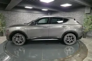Vue de profil côté gauche de l'Alfa Romeo Tonale gris métallisé avec jantes alliage 18 pouces en showroom.